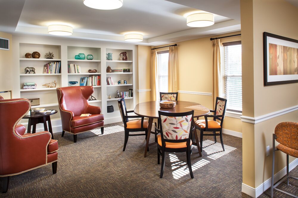 Library with built-in bookshelves, armchairs and a game table